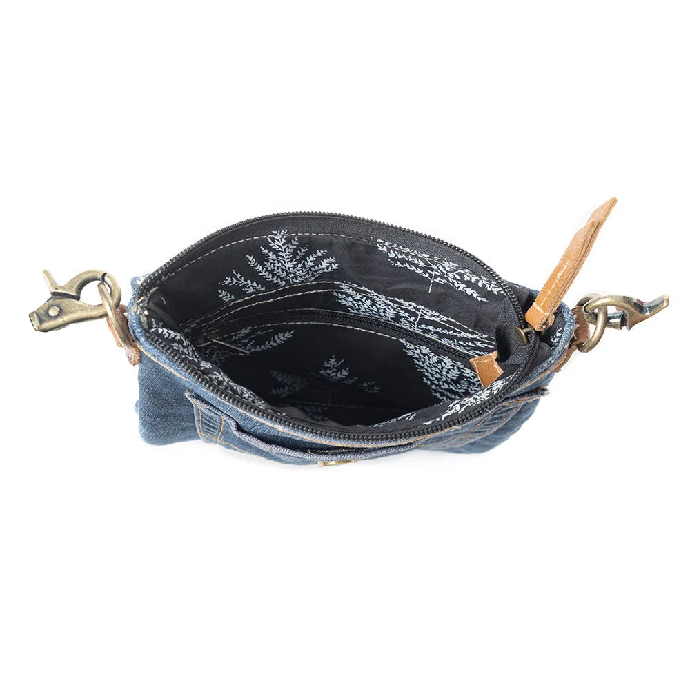 Interior of Myra Dahlia Denim Crossbody Bag with dark floral lining and zippered opening