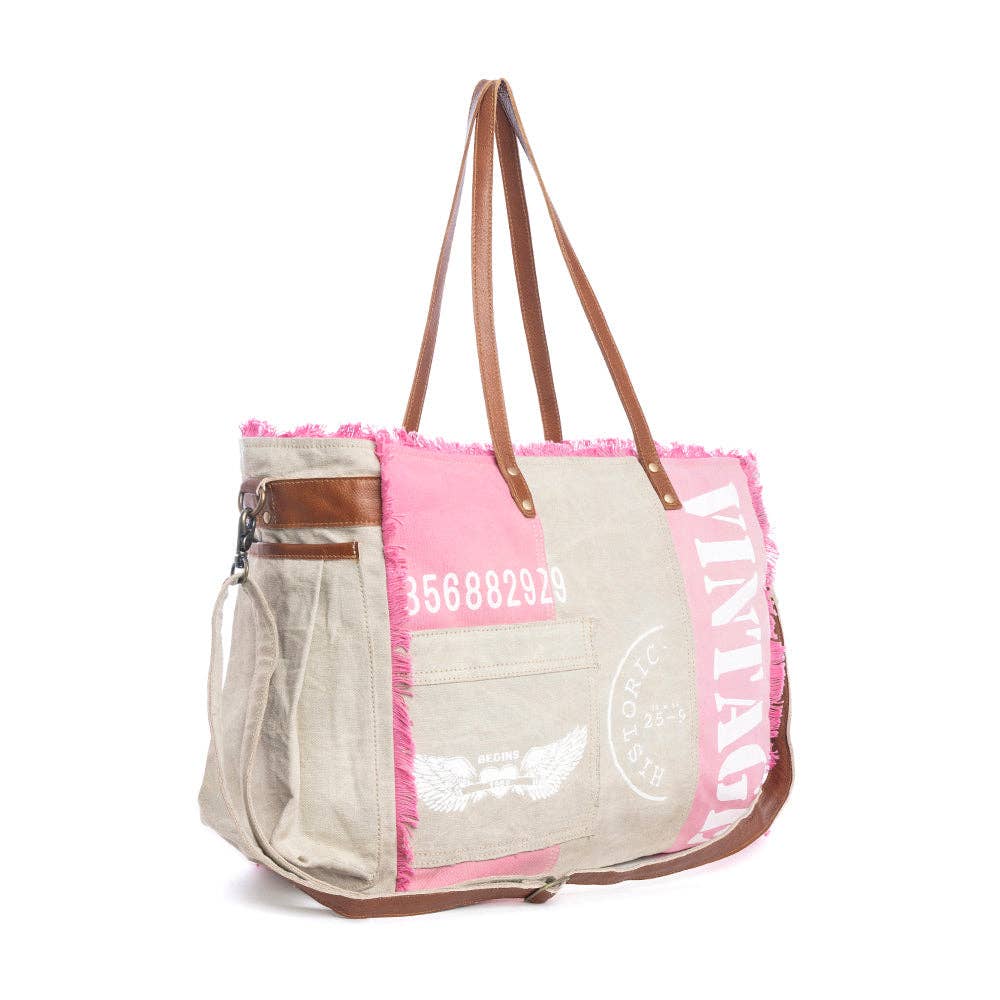 Myra Queen Creek Weekender Bag in Pink side view with woven canvas, leather handles, frayed edges, and detachable shoulder strap